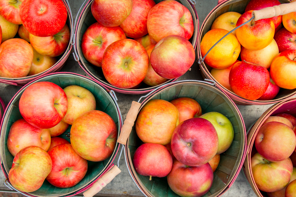 A group of baskets filled with apples and oranges.