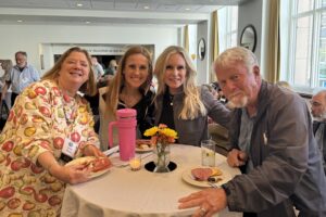A group of people sitting at a table with food.